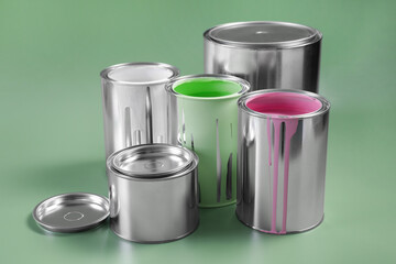 Cans of paints on light green background