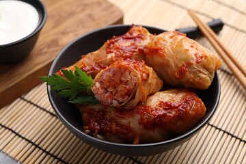 Delicious stuffed cabbage rolls cooked with homemade tomato sauce on table, closeup