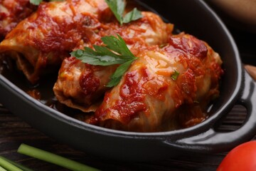 Delicious stuffed cabbage rolls cooked with homemade tomato sauce on table, closeup