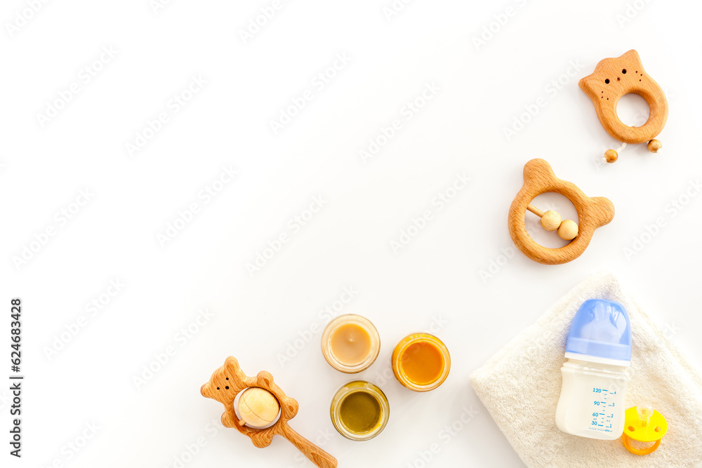 Wall mural feeding baby bottle with milk and kids accessories on table, top view. childcare concept