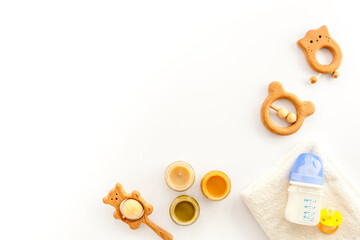 Feeding baby bottle with milk and kids accessories on table, top view. Childcare concept