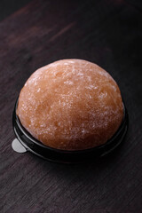 Delicious sweet mochi dessert with toppings on a dark concrete background