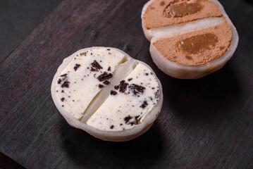 Delicious sweet mochi dessert with toppings on a dark concrete background