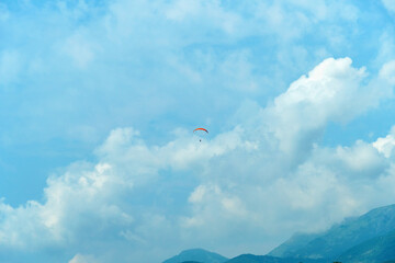 the paraglider is high in the sky between the clouds