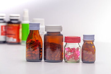 Unlabeled pill bottles lined up on a white background