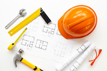 Top view of construction helmet on drawing blueprints for house designing and architect plan