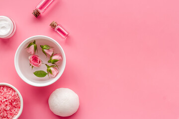 Pink roses cosmetic products set with flowers essential oil. Beauty care concept.