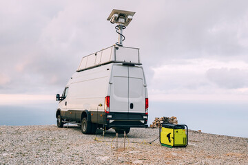 a truck equipped with scientific equipment, including an antenna and generator.