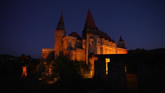 Corvin (Hunyad) Castle in Hunedoara during the night. 4K wide angle video pan camera movement with this amazing medieval castle landmark in Romania.