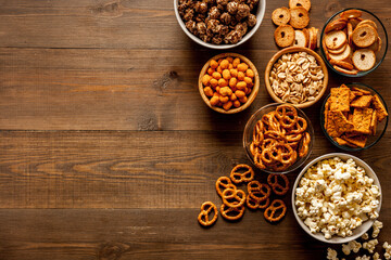 Bowls with different salty snacks for party. Fast food background