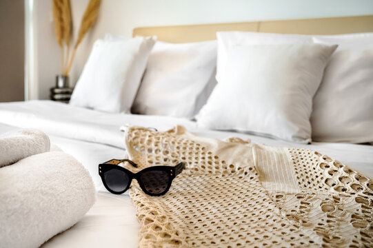 Capture the essence of a holiday-themed bedroom with this close-up photograph showcasing a pair of sunglasses resting on the bed, set against a beautifully blurred background. 