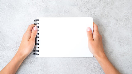 Girl holding white notebook view from above