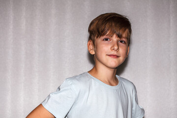 nine year old boy looks at the camera and smiles. close-up portrait