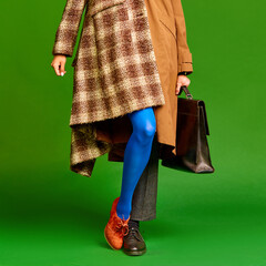 Man and woman wearing warm color in retro style against green studio background. Autumn style. Concept of fashion, outlook, style, retro and vintage, creativity, ad. Pop art