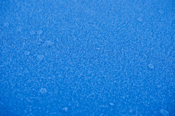 frost on blue metal,texture of frost on a blue sheet of metal, with a shallow depth of field
