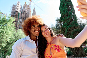 multiethnic couple of tourists visiting Barcelona, Spain and taking selfie