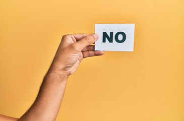 Hand of caucasian man holding paper with no word over isolated yellow background