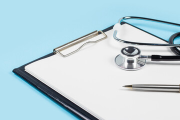 Stethoscope and pen laying on patient information blank