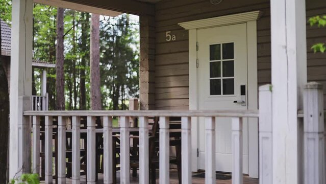 Country house made of wood with an open veranda in summer in a pine forest