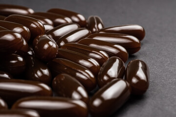 Lecithin gel pills capsule on dark background. Soy lecithin benefits for skin, digestion, lower cholesterol.