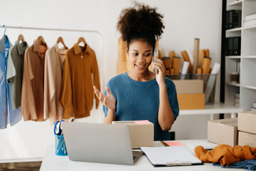 Young African business owner woman prepare parcel box and standing check online orders for deliver...