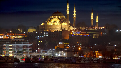 Istanbul, Turkey - February 2023: illuminated Hagia Sofia Mosque and the calm sea water at Bosphorus at night