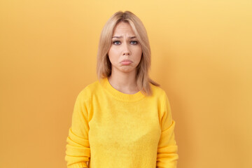 Young caucasian woman wearing yellow sweater depressed and worry for distress, crying angry and afraid. sad expression.