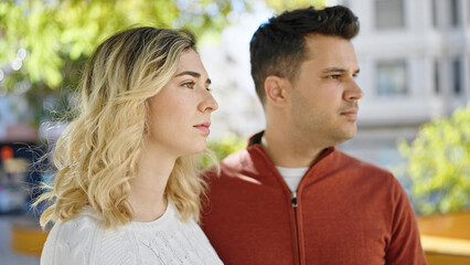 Obraz premium Man and woman couple standing together with relaxed expression at park