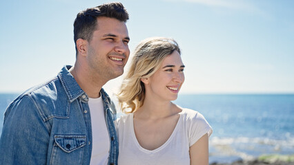Naklejka premium Man and woman couple smiling confident standing together at seaside