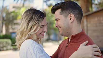 Obraz premium Man and woman couple smiling confident hugging each other at park