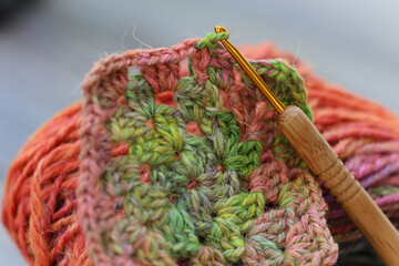 Closeup detail of crochet work with a colourful skein of organic natural handspun and handdyed...
