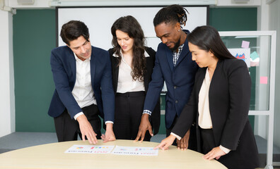 Group of business people discussing the charts and graphs showing the results of their successful teamwork