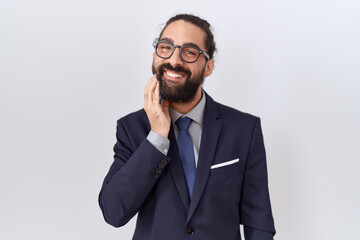 Hispanic man with beard wearing suit and tie touching mouth with hand with painful expression because of toothache or dental illness on teeth. dentist