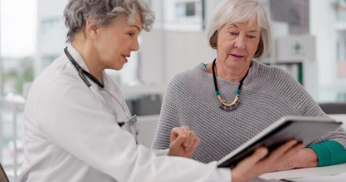 Senior doctor, tablet and consulting patient for healthcare advice, prescription or diagnosis at hospital. Mature medical professional talking to elderly female person on technology for consultation