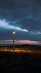 Sunset on Normandy beach with street lamp