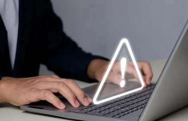 Businessman or developer programmer on laptop with warning triangle sign for error notification and maintenance concept. Work remotely with a laptop connected application.