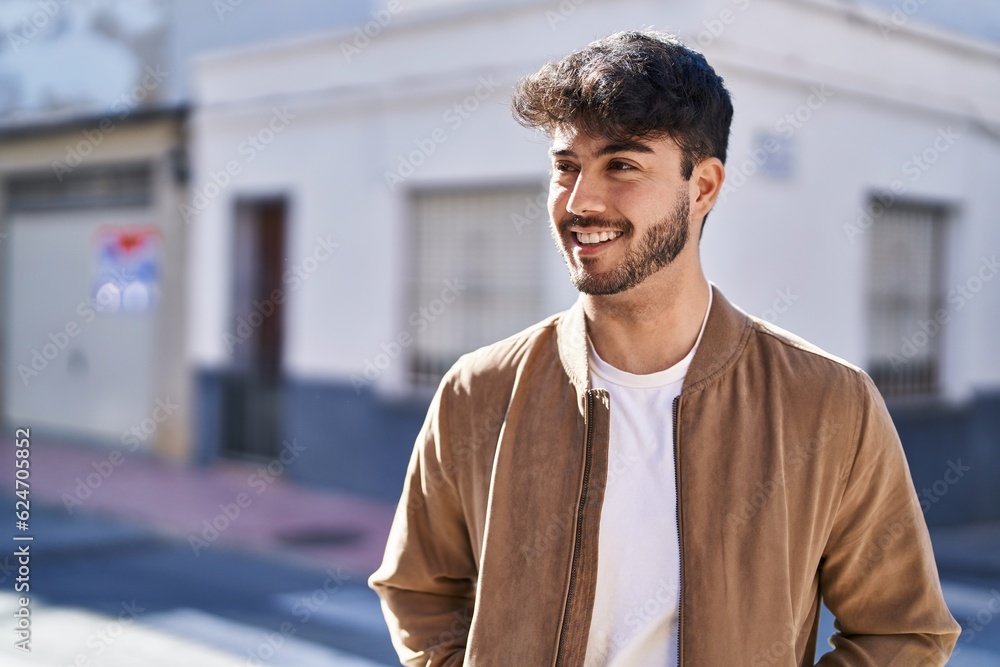 Sticker young hispanic man smiling confident looking to the side at street