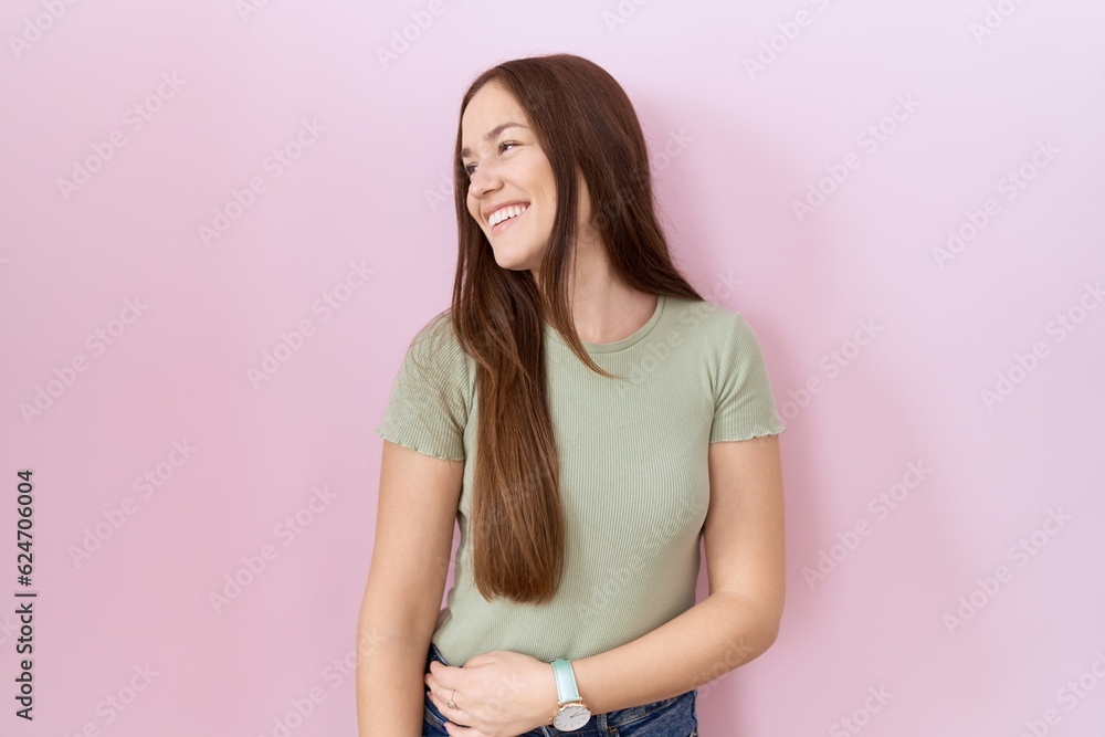 Sticker beautiful brunette woman standing over pink background looking away to side with smile on face, natu