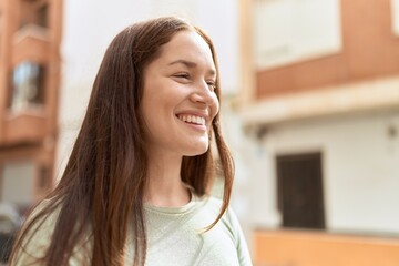 Young beautiful woman smiling confident looking to the side at street