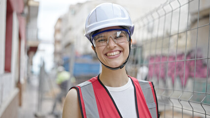 Young beautiful hispanic woman builder smiling confident standing at street