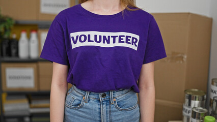 Young blonde woman volunteer standing at charity center