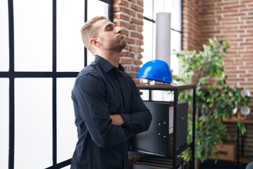 Young caucasian man business worker standing with arms crossed gesture and worried expression at...