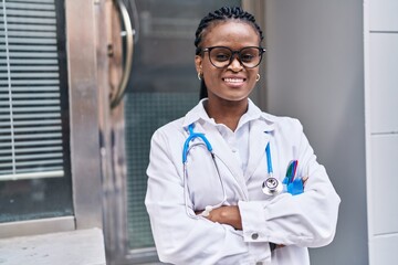 African american woman doctor smiling confident standing with arms crossed gesture at hospital