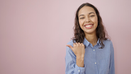 Young beautiful hispanic woman smiling confident pointing to the side over isolated pink background