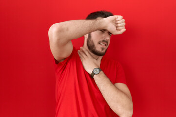 Young hispanic man wearing casual red t shirt touching forehead for illness and fever, flu and cold, virus sick