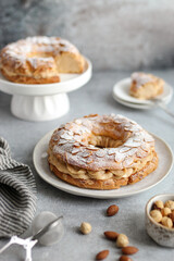 Round-shaped classic French dessert Paris Brest with almonds and hazelnuts on a white plate