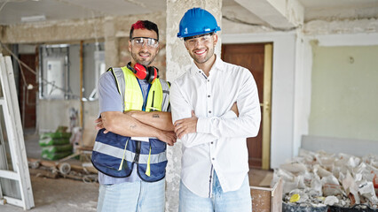 Two men builder and architect smiling confident standing with arms crossed gesture at construction...