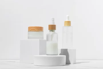 Foto op Plexiglas Apotheek Cosmetics packaging. Set of different cosmetic jars and tubes of cream on white podiums. Blank packaging. Natural beauty spa product concept. Beauty.Mock-up