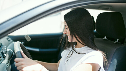 Fototapeta na wymiar Young beautiful hispanic woman smiling confident driving car at street