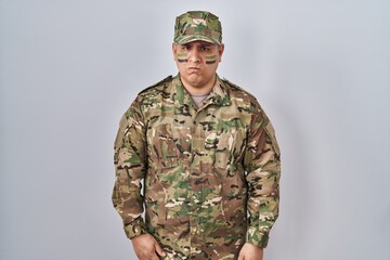 Hispanic young man wearing camouflage army uniform skeptic and nervous, frowning upset because of problem. negative person.